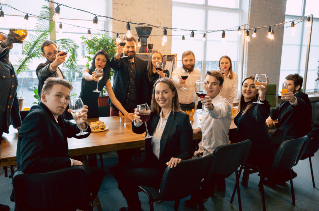 corporate party people cheering with glass of wine